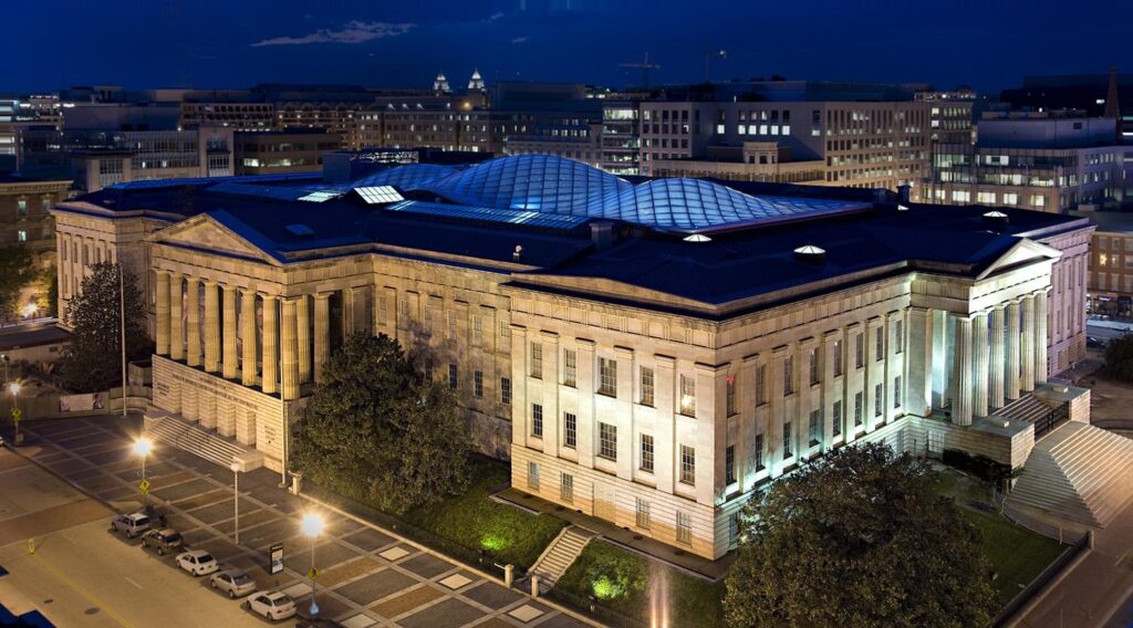 Smithsonian American Art Museum illuminated at night, showcasing its architectural features and modern glass roof, located in Washington DC, a notable community served by Dr. Glass and Doors.